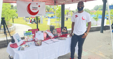 RedMoon Project | Sickle Cell Disease News | Cory Lewis in front of a RedMoon Project booth