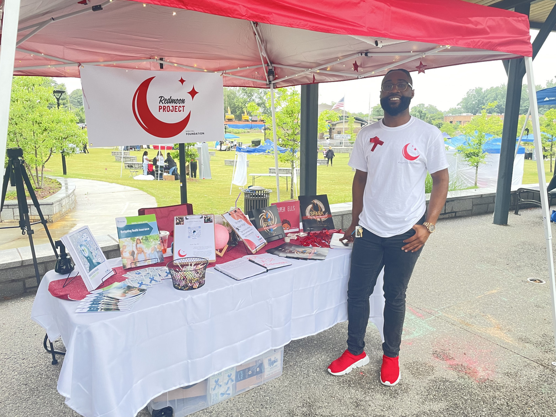 RedMoon Project | Sickle Cell Disease News | Cory Lewis in front of a RedMoon Project booth