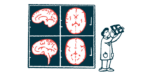 A researcher holds up a scan of a brain, which is also projected on the wall beside him.