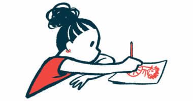 A child sits at a table and draws a picture on a sheet of paper.