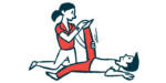A person in red pants has their leg stretched by a physical therapist.